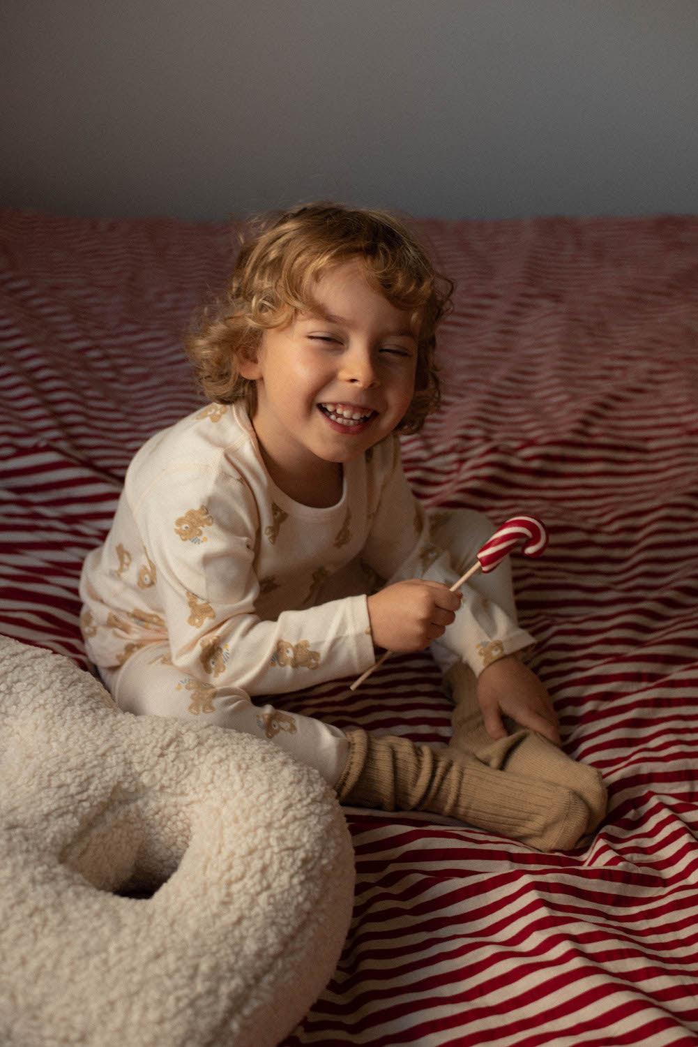 Boucle Letter cushion B by Bettys Home Teddy Letter Pillow on bed next to smiling cute boy