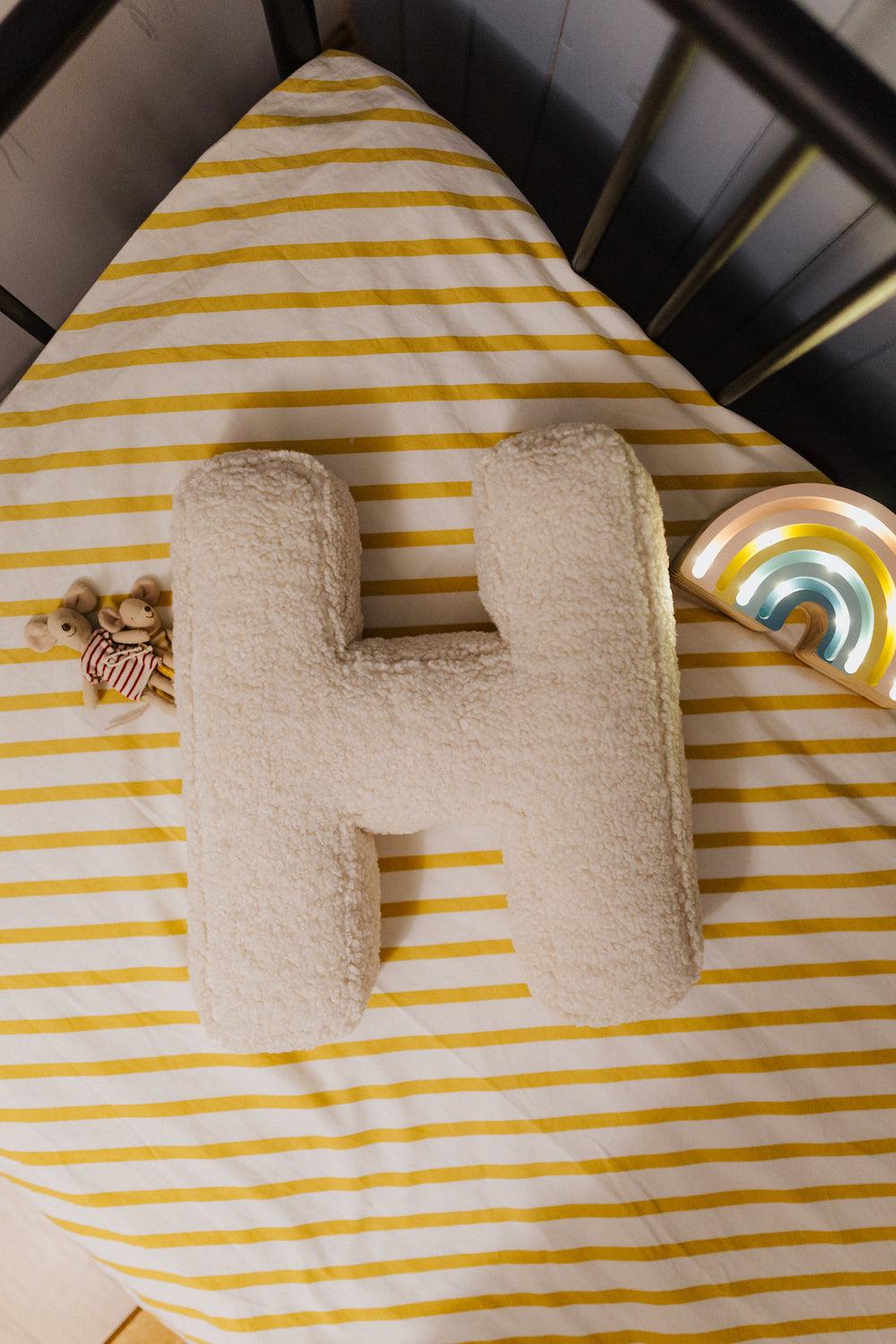 Boucle Letter cushion H by Bettys Home Teddy Letter Pillow lying in kids crib as kids room decoration