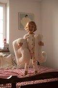 small baby boy standing on bed with Boucle Letter cushion B and J by Bettys Home Teddy Letter Pillow in hands