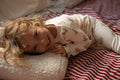 little boy lying on Boucle Letter Cushion J Teddy Letter Pillow by Bettys Home on bed 